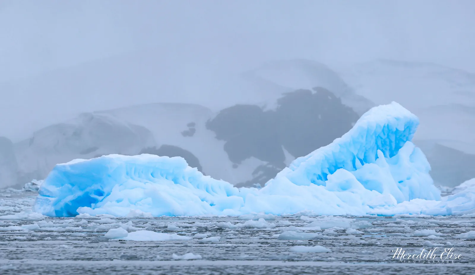 Sculpted blue iceberg adrift in misty Antarctic waters — Antarctica fine art print