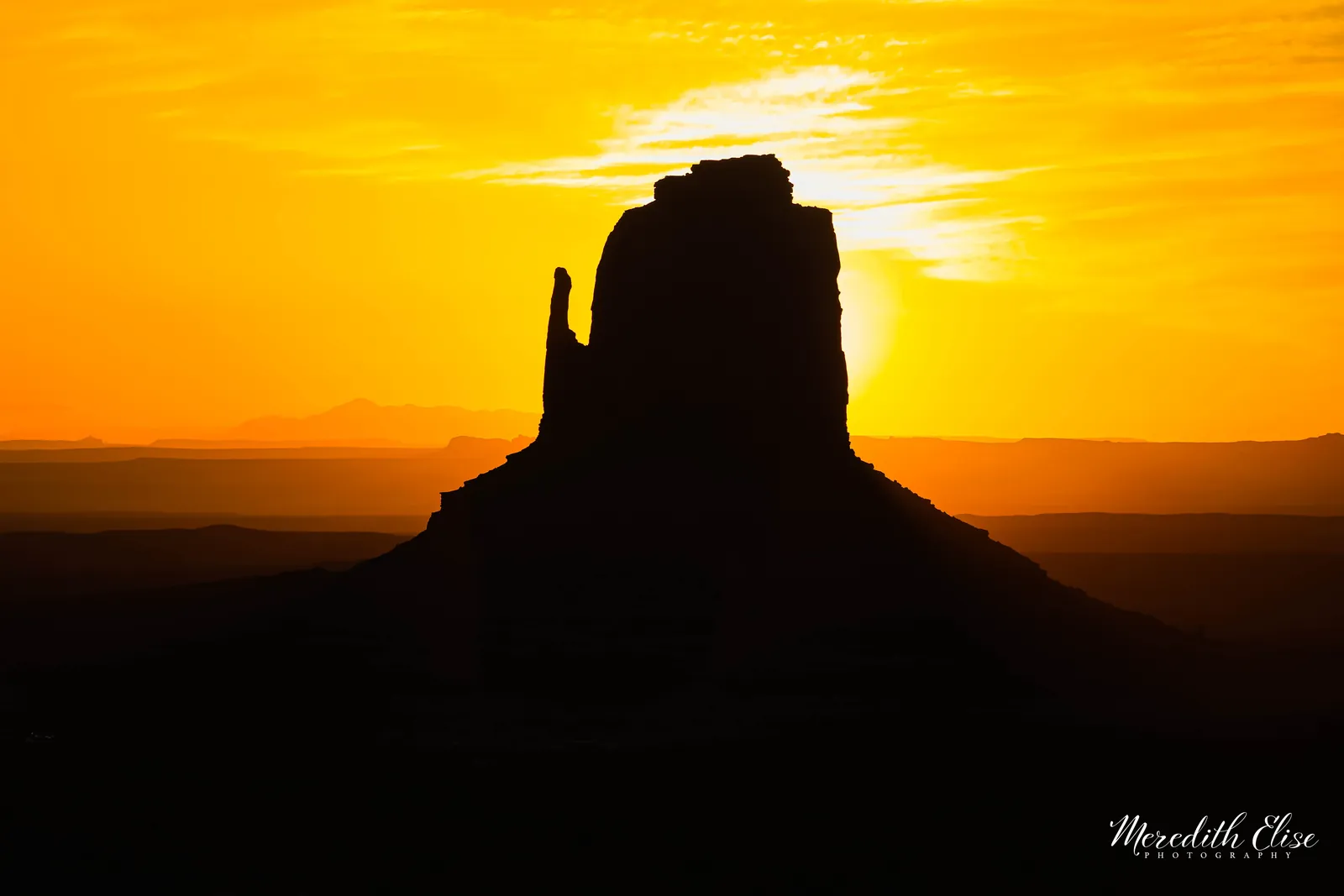 East Mitten Butte silhouetted against a golden orange sunrise in Monument Valley — Arizona fine art print