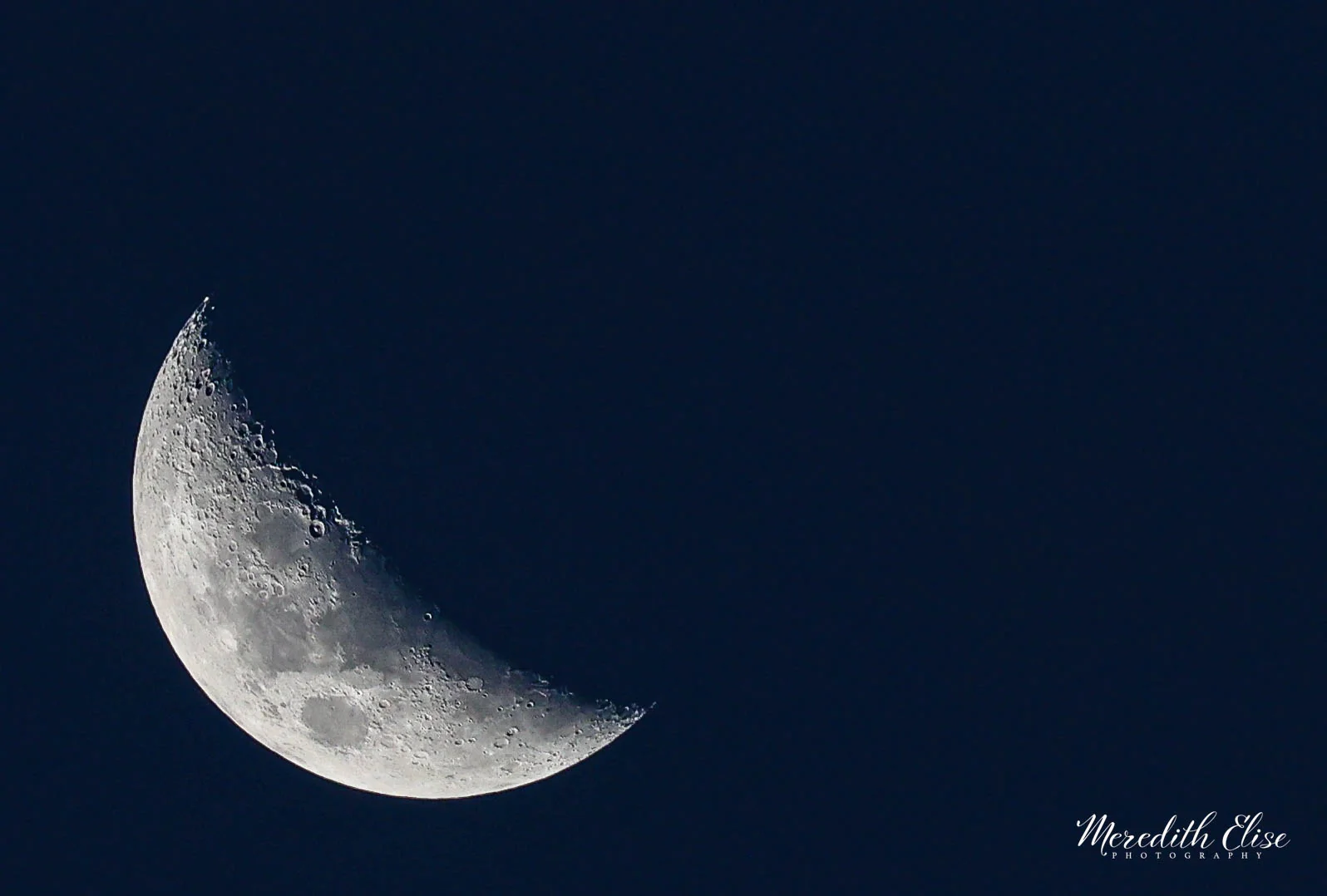 Detailed half moon with craters etched along the terminator against a deep night sky — astrophotography fine art print
