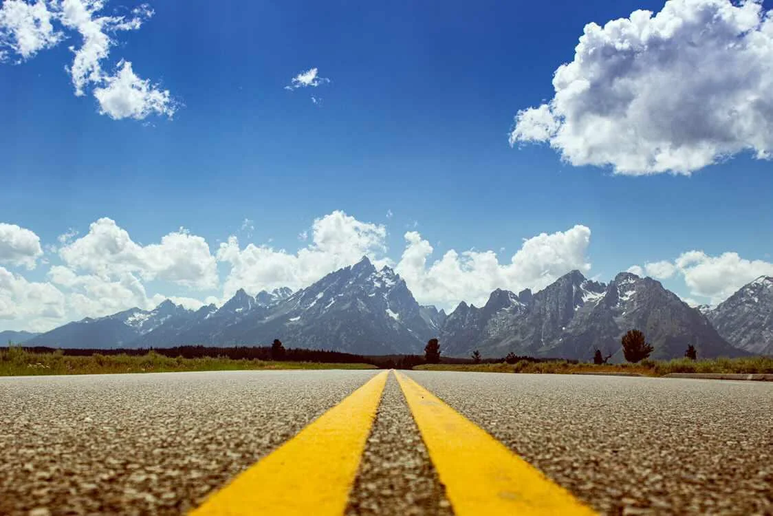 Highway center lines leading straight toward the Grand Teton mountains — Wyoming fine art print