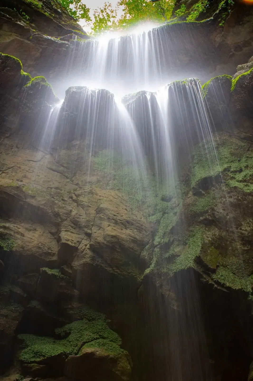 Curtains of water streaming over a mossy cave opening at Hidden Falls — fine art print