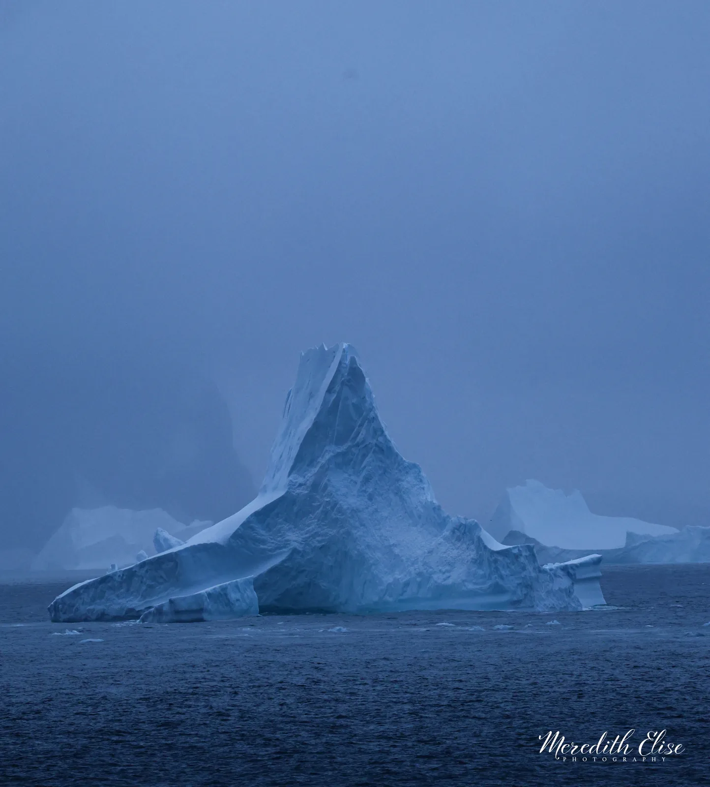 Towering cathedral iceberg rising through blue-grey mist — Antarctica fine art print