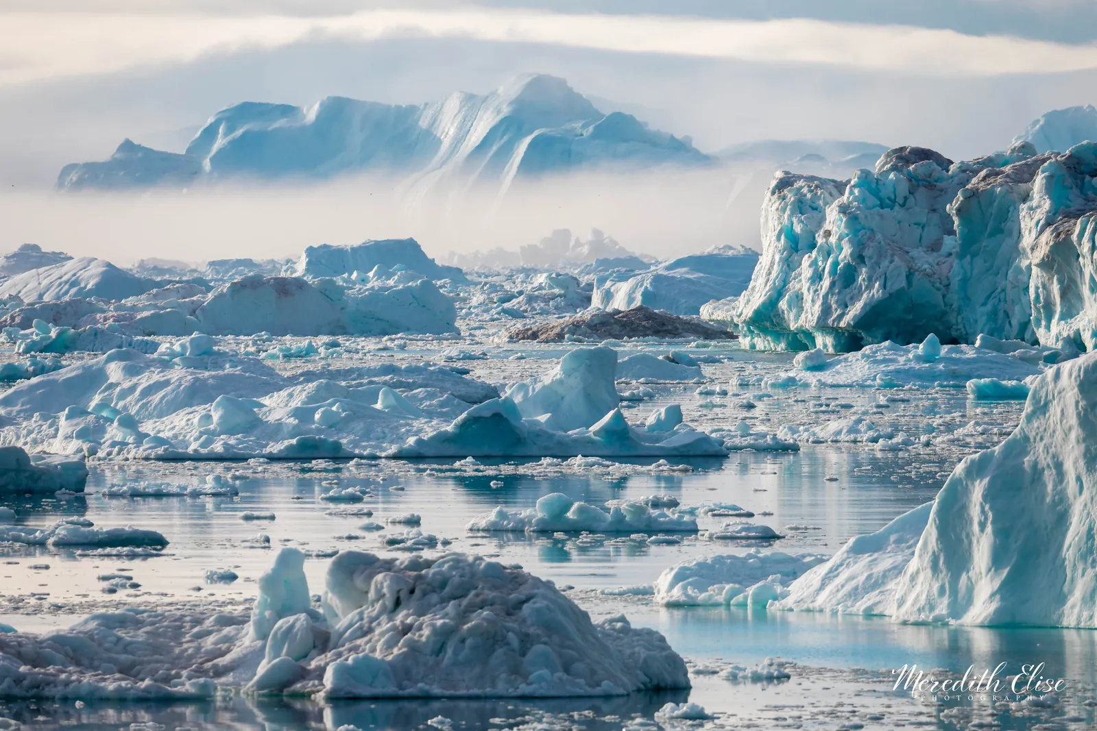 Sea of icebergs filling a foggy fjord from shore to horizon — Greenland fine art print